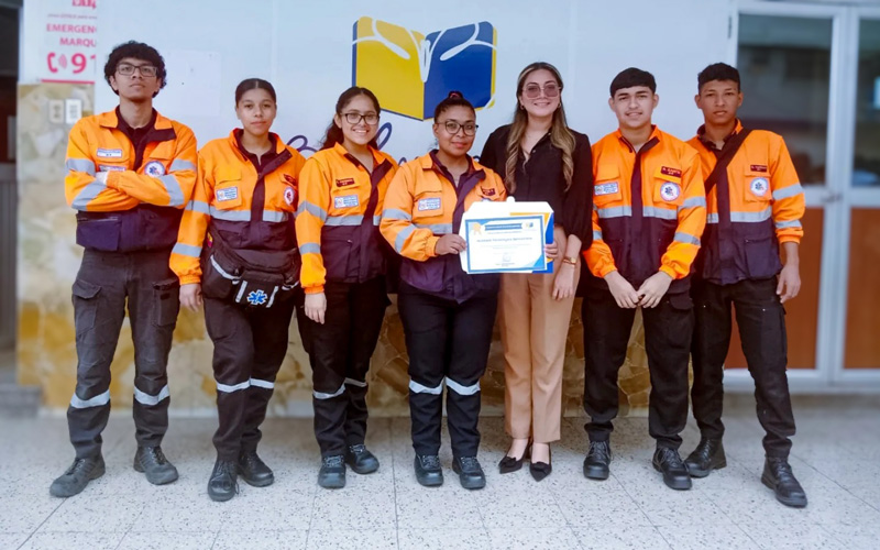 Estudiantes de Emergencias Médicas instruyen a estudiantes de colegio en primeros auxilios. 